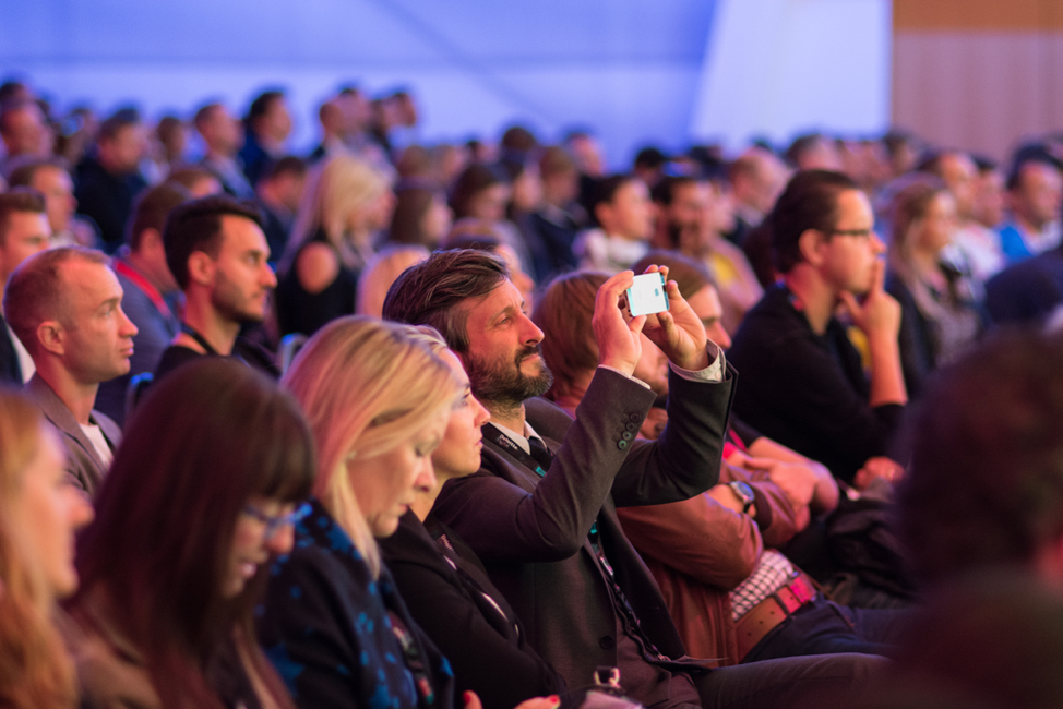 employees at a conference posting to social media